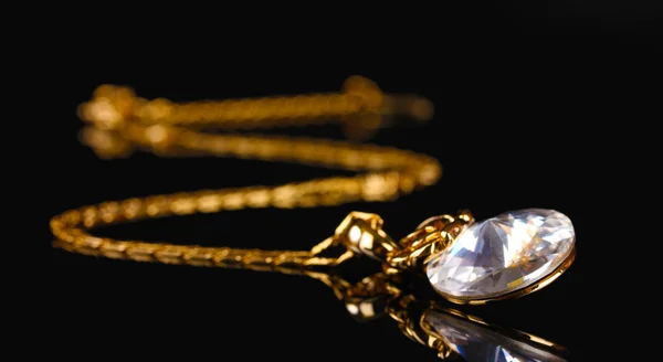 Красиве золоте намисто з дорогоцінним камінням на чорному тлі — стокове фото