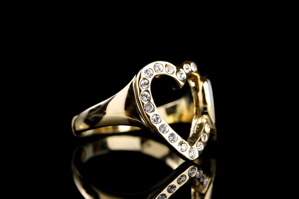 Bellissimo anello in oro con pietre preziose su sfondo nero — Foto Stock