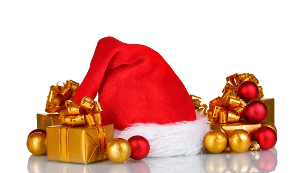 Рождественская шапка, подарки и рождественские шары — стоковое фото