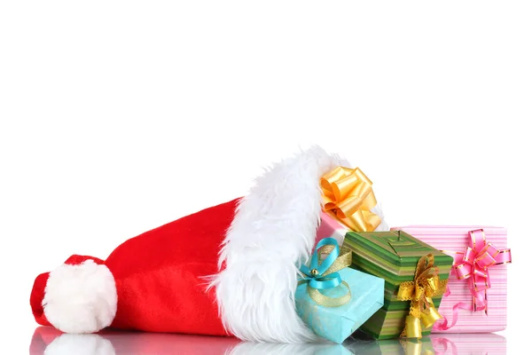 Schöne Weihnachtsmütze und Geschenke isoliert auf weiß — Stockfoto