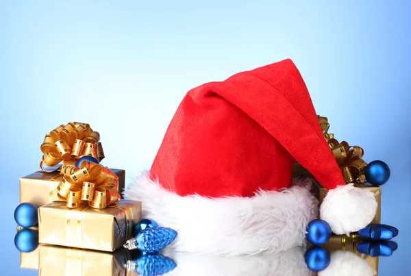 美しいクリスマスの帽子、ギフト、青い背景にクリスマス ボール — ストック写真