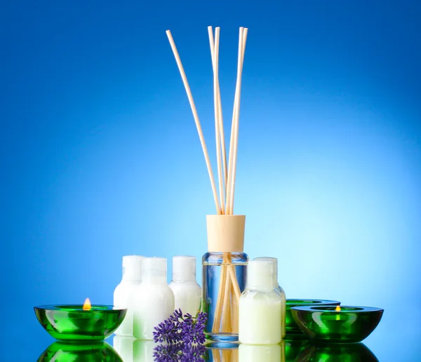 Fles luchtverfrisser, lavendel en kaarsen op blauwe achtergrond — Stockfoto