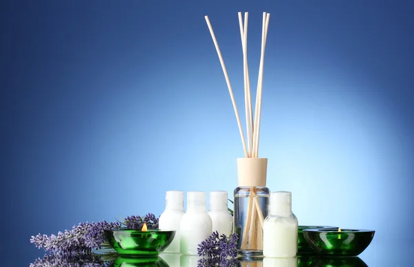 Fles luchtverfrisser, lavendel en kaarsen op blauwe achtergrond — Stockfoto