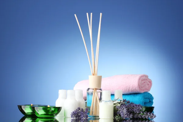 Flasche Lufterfrischer, Lavendel, Handtücher und Kerzen auf blauem Hintergrund — Stockfoto
