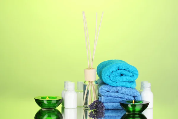 瓶空气清新剂、 薰衣草和毛巾上的绿色背景 — 图库照片