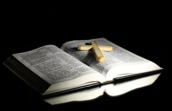 Biblia santa abierta rusa con cruz de madera sobre fondo negro — Foto de Stock