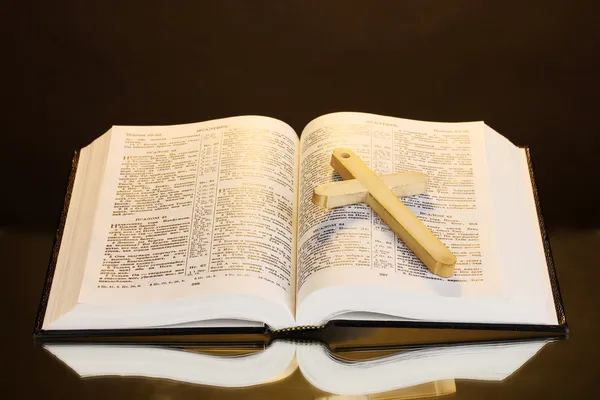 Biblia santa abierta rusa con cruz de madera sobre fondo marrón — Foto de Stock