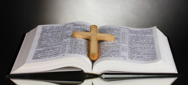 Ruská otevřené holy bible s dřevěný kříž na černém pozadí — Stock fotografie