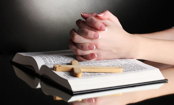 Vrouwelijke handen op open Russische Heilige Bijbel op zwart backround — Stockfoto