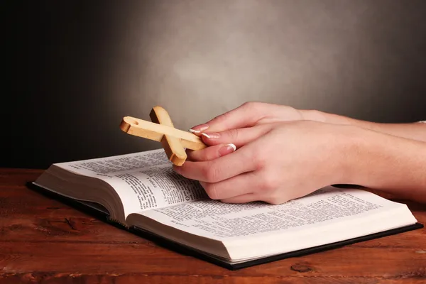 Hands folded in prayer over open russian Holy Bible — Stock Photo, Image