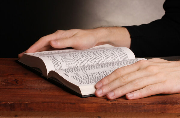 Reading open russian holy bible on wooden table