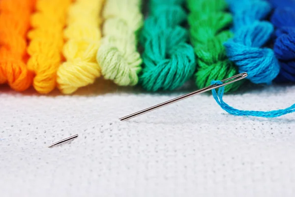 Sewing threads for embroidery and needle with a thread on white cotton — Stock Photo, Image