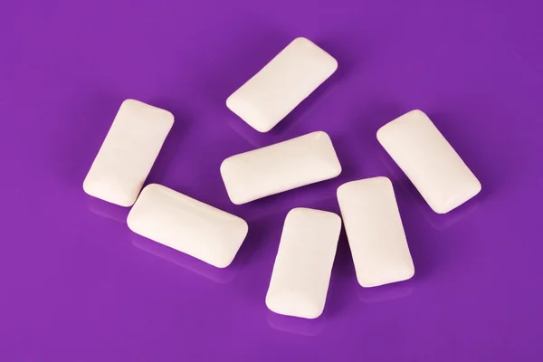 Chewing gums on purple background — Stock Photo, Image
