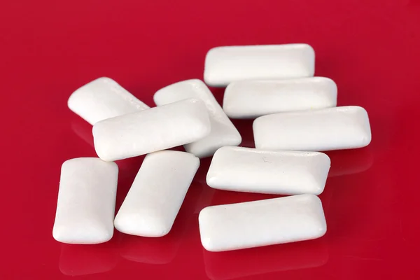 Kauwgom tandvlees op rode achtergrond — Stockfoto