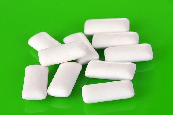 Chewing gums on green background — Stock Photo, Image