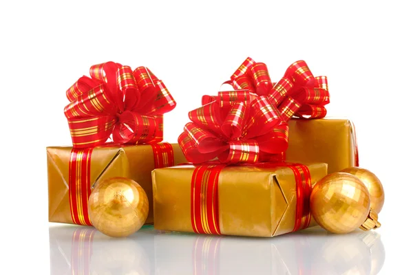 Vackra gyllene gåvor med rött band och julgranskulor isolerad på whit — Stockfoto