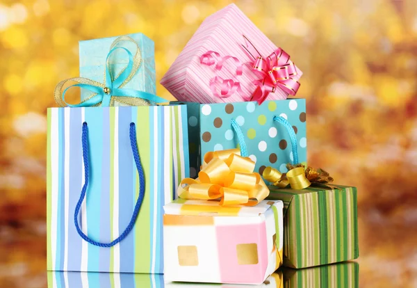 Lyse gaveposer og gaver på gul bakgrunn – stockfoto