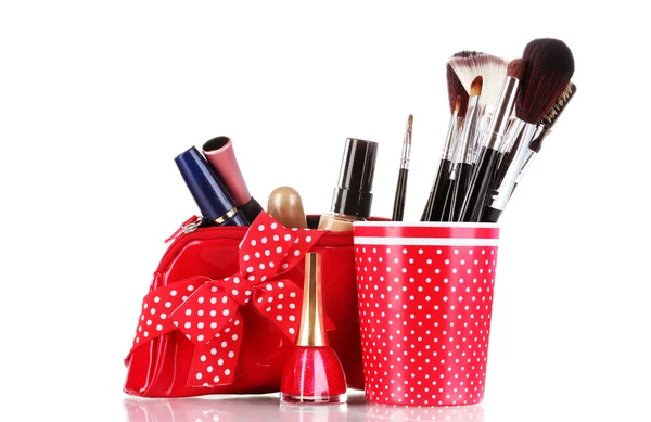 Verre rouge avec brosses et sac de maquillage avec cosmétiques isolés sur blanc — Photo