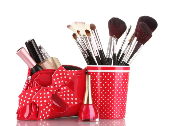 Červené sklo s kartáčky a make-up sáček s kosmetikou izolovaných na bílém — Stock fotografie