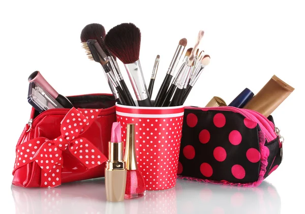 Vidro vermelho com escovas e saco de maquiagem com cosméticos isolados em branco — Fotografia de Stock