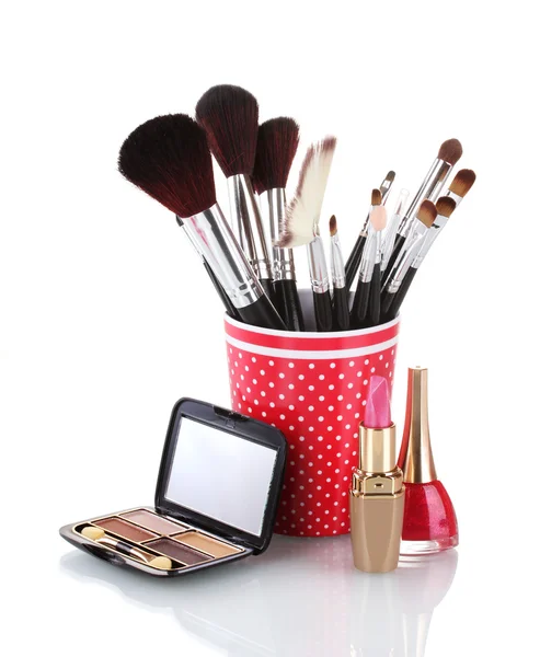 Red glass with brushes and cosmetics isolated on white — Stock Photo, Image