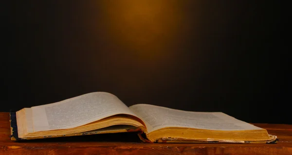 Стара книга на дерев'яному столі на коричневому фоні — стокове фото