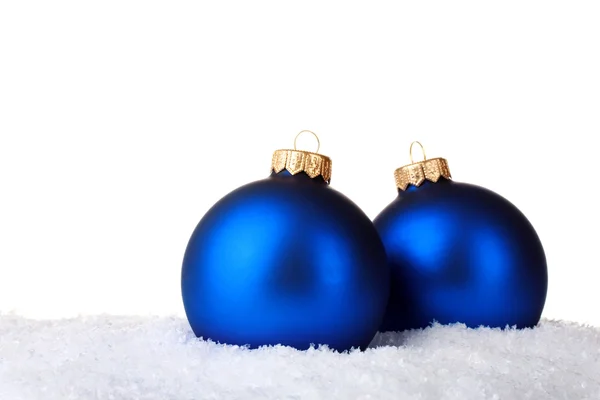 Vackra blå julgranskulor i snön isolerade på vit — Stockfoto