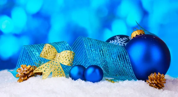 Güzel mavi Noel topları ve koni içinde kar üzerinde mavi arka plan — Stok fotoğraf