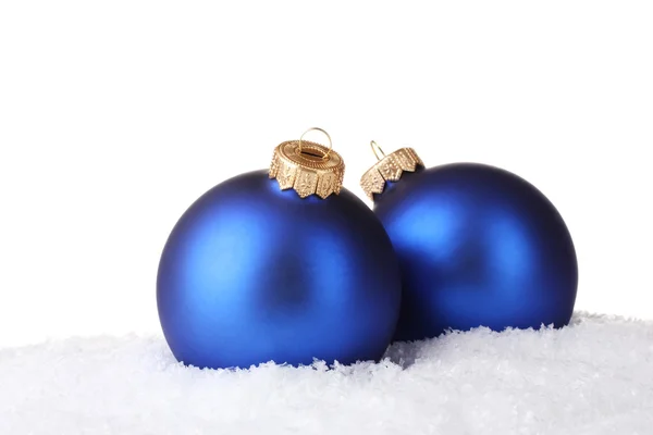 Vackra blå julgranskulor i snön isolerade på vit — Stockfoto