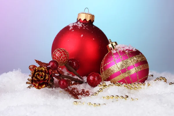 Beautiful Christmas balls and cone on snow on bright background — Stockfoto