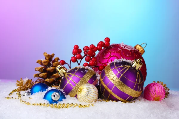 Красивые рождественские шары и конусы на снегу на ярком фоне — стоковое фото