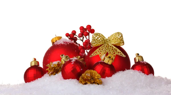 Όμορφο κόκκινο Χριστούγεννα μπάλες και κώνους στο χιόνι που απομονώνονται σε λευκό — Φωτογραφία Αρχείου