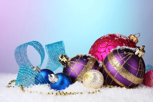 Beautiful Christmas balls and cones on snow on bright background — Stock Photo, Image
