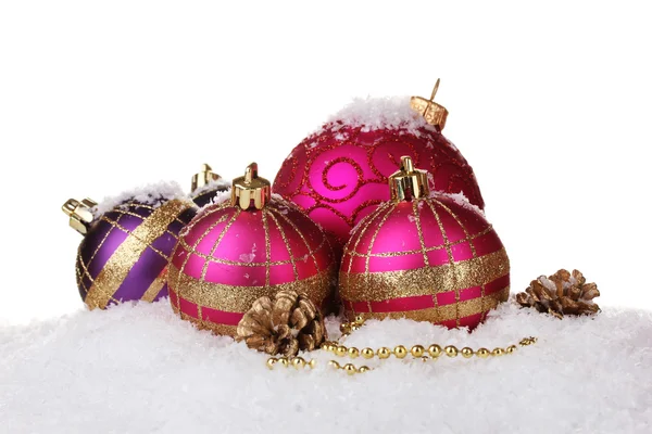 Beautiful pink Christmas balls and cones on snow isolated on white — Stock Photo, Image