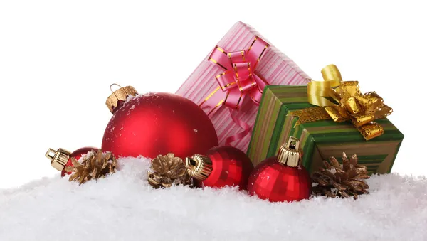Hermosas bolas rojas de Navidad, regalos y conos en la nieve aislado en blanco —  Fotos de Stock