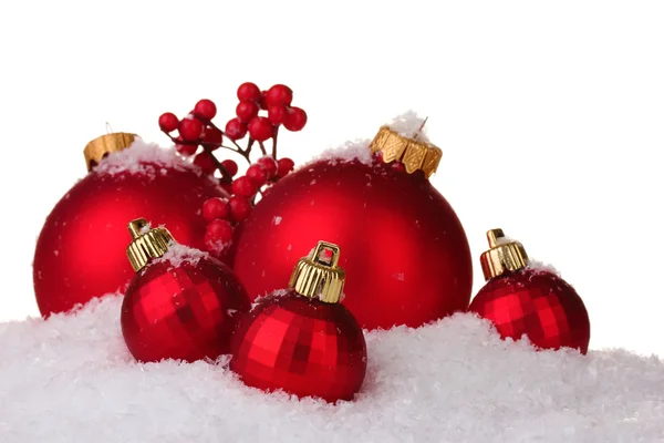 Красивые красные рождественские шары и шишки на снегу изолированы на белом — стоковое фото