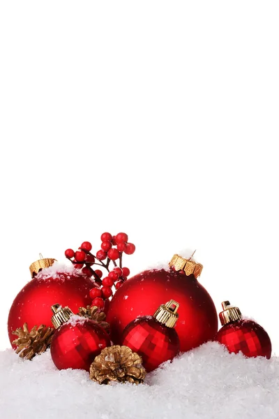 Vackra röda julgranskulor och kottar på snön isolerade på vit — Stockfoto