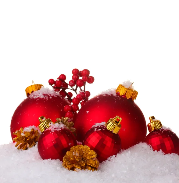 Beautiful red Christmas balls and cones on snow isolated on white — Stock Photo, Image