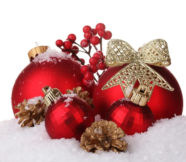 Belle palle di Natale rosse e coni sulla neve isolati su bianco — Foto Stock