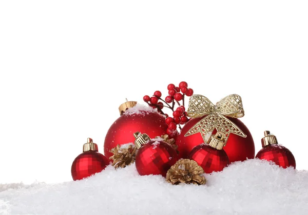 Belle palle di Natale rosse e coni sulla neve isolati su bianco — Foto Stock