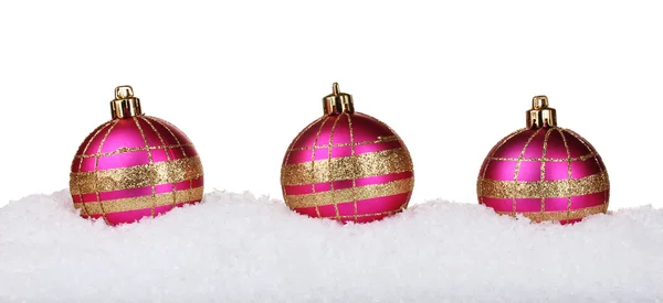 Mooie roze kerstballen in sneeuw geïsoleerd op wit — Stockfoto
