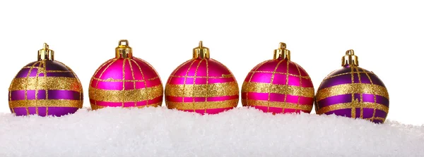 Belas bolas de Natal rosa e roxo na neve isolada no branco — Fotografia de Stock