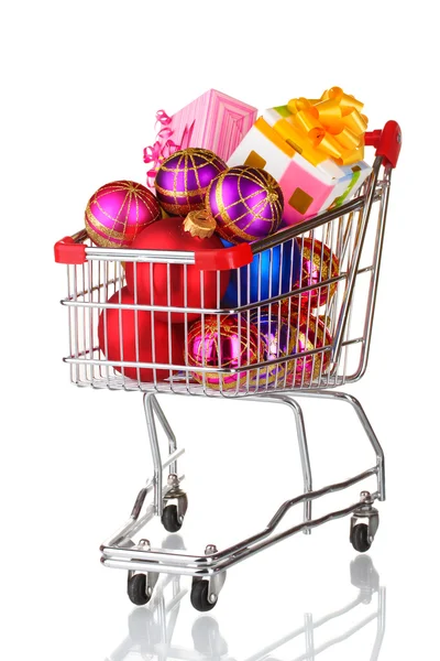 Beautiful bright Christmas balls and gifts in the cart isolated on white — Stock Photo, Image