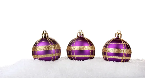 Beautiful purple Christmas balls in snow isolated on white — Stock Photo, Image