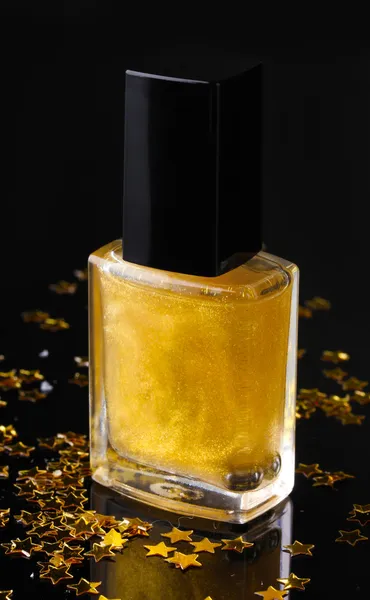 stock image Golden nail polish on black background