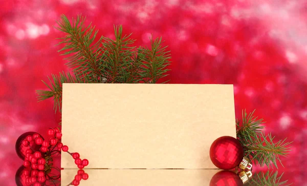 Prázdná pohlednice, vánoční koule a jedle na červeném pozadí — Stock fotografie