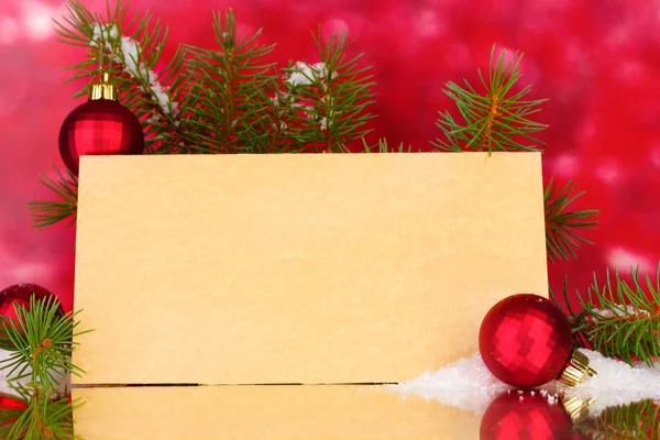 Cartão postal em branco, bolas de Natal e abeto no fundo vermelho — Fotografia de Stock