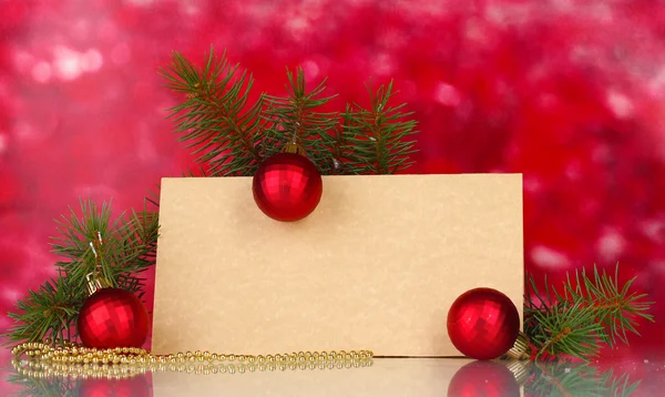 Cartão postal em branco, bolas de Natal e abeto no fundo vermelho — Fotografia de Stock