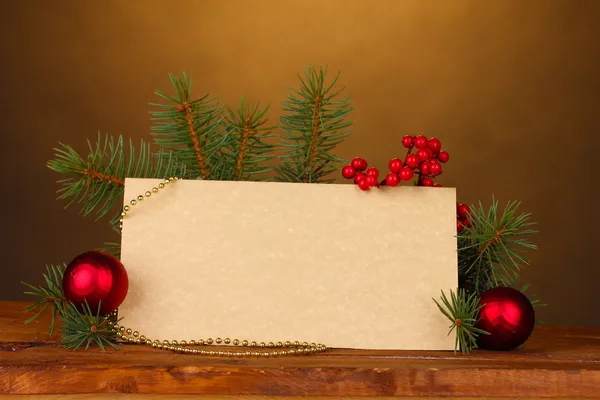 Чистая открытка, рождественские шары и елка на деревянном столе на коричневом бэкге — стоковое фото