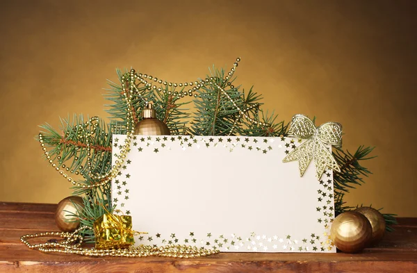 Cartolina bianca, palline di Natale e abete su tavolo di legno su dorso marrone — Foto Stock